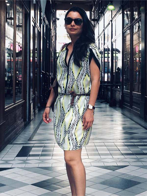 Client wearing a curated wardrobe piece, walking through a city arcade